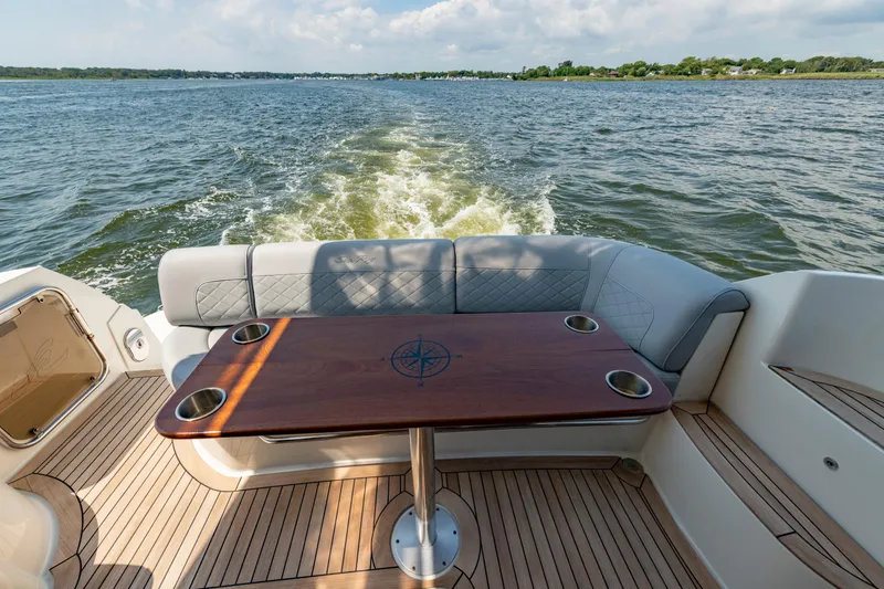 Slide: The Image of Luxurious 2017 Sea Ray Fly 510 yacht with elegant deck seating and wooden table on open water. - 24
