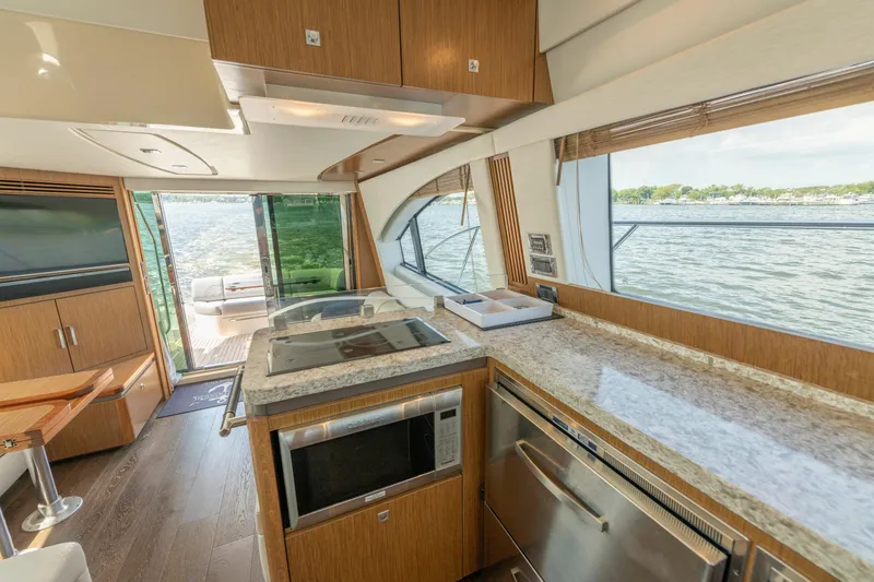 Slide: The Image of Luxurious interior of 2017 Sea Ray Fly 510 yacht with modern kitchen and scenic water view. - 38