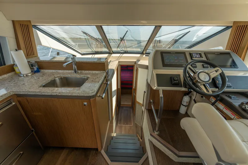 Slide: The Image of Luxurious 2017 Sea Ray Fly 510 yacht interior with helm, sink, and modern controls. - 43