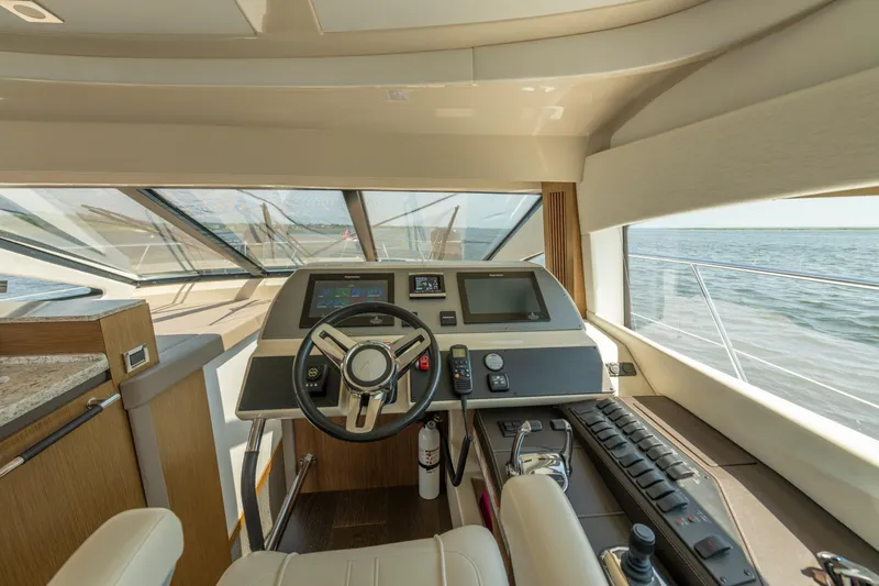 Slide: The Image of 2017 Sea Ray Fly 510 yacht helm with modern controls and panoramic ocean view. - 45