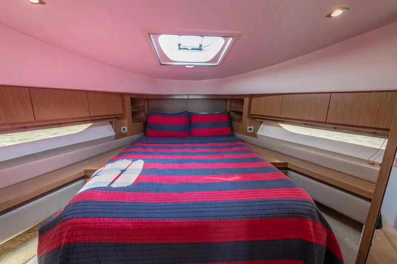 Slide: The Image of Luxurious 2017 Sea Ray Fly 510 yacht bedroom with striped bedding and natural light. - 58