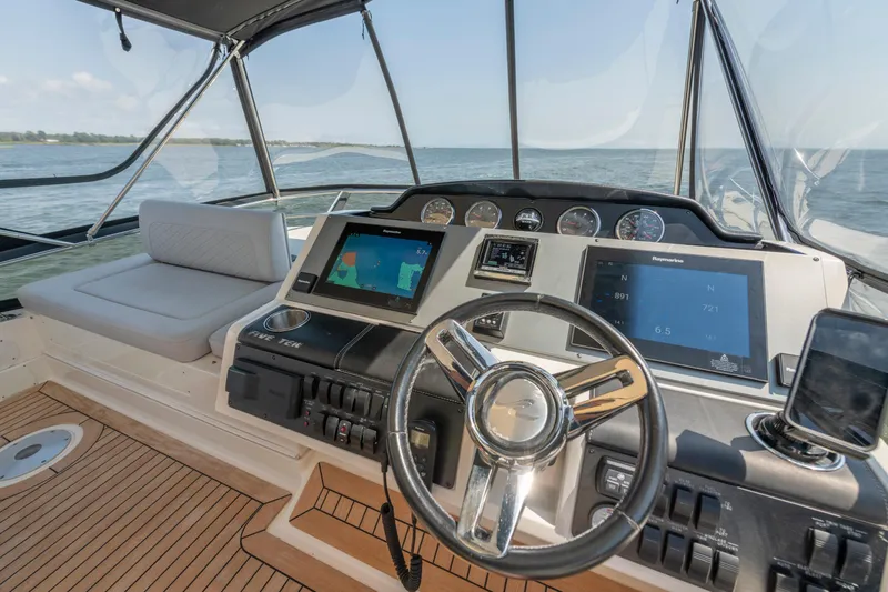 Slide: The Image of 2017 Sea Ray Fly 510 yacht helm with navigation screens and steering wheel. - 76
