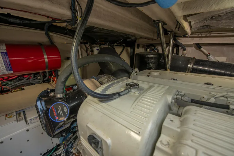 Slide: The Image of Engine room of 2017 Sea Ray Fly 510 yacht, showcasing mechanical components and fire extinguisher. - 93