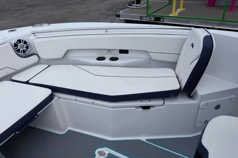 Slide: The Image of 2025 Stingray 253 CC boat interior with white cushioned seating and cup holders. - 13