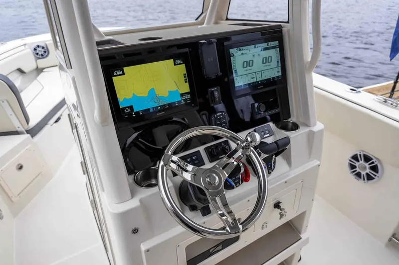 Slide: The Image of Manufacturer Provided Image: 2025 Stingray 253 CC boat dashboard with navigation screens and steering wheel. - 22