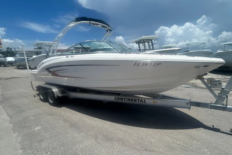 Slide: The Image of 2023 Chaparral 23 SSi OB boat on trailer, parked outdoors under clear blue sky. - 1