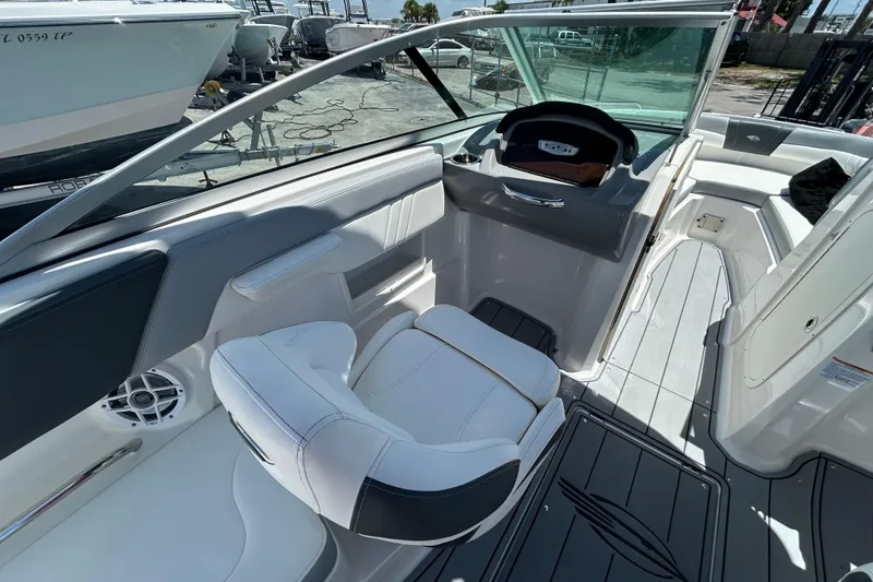Slide: The Image of 2023 Chaparral 23 SSi OB boat interior with white seating and modern dashboard. - 11