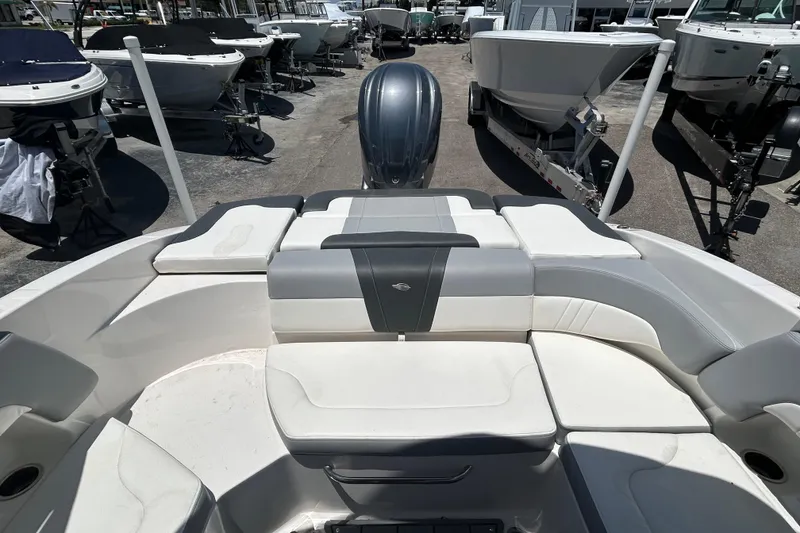 Slide: The Image of 2023 Chaparral 23 SSi OB boat interior with cushioned seating and outboard motor. - 13