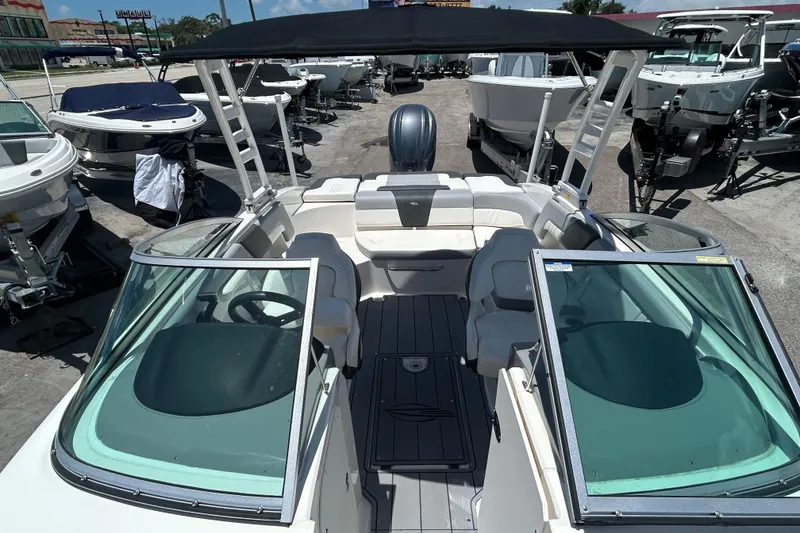 Slide: The Image of 2023 Chaparral 23 SSi OB boat with open cockpit and seating, displayed outdoors. - 15
