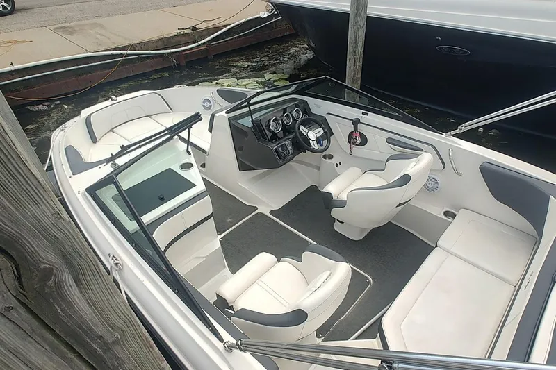 Slide: The Image of 2018 Sea Ray SPX 190 boat interior with white seating and modern dashboard. - 12