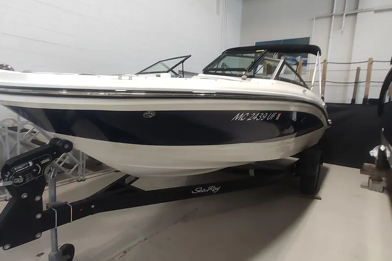 Slide: The Image of 2018 Sea Ray SPX 190 boat on trailer in indoor storage. - 2
