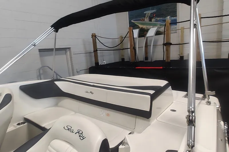 Slide: The Image of 2018 Sea Ray SPX 190 boat interior with seating and canopy in showroom. - 4