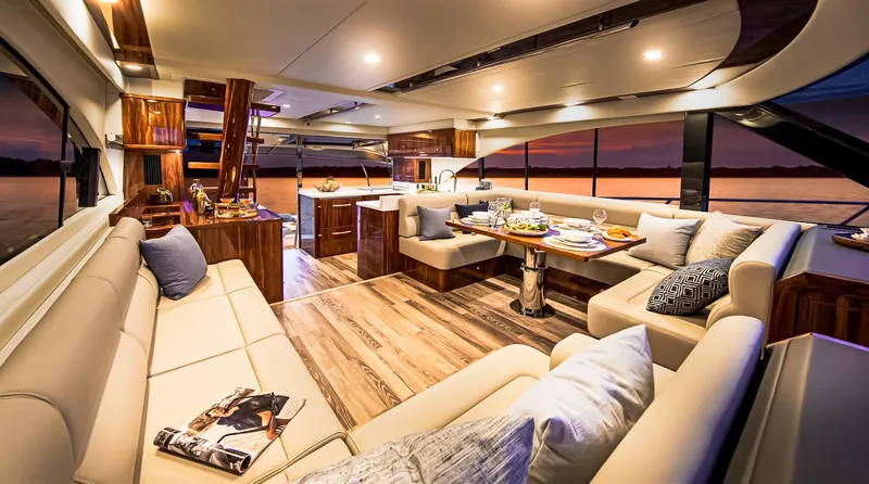 Slide: The Image of Luxurious interior of 2023 Riviera 57 Enclosed Flybridge yacht with elegant seating and dining area. - 5