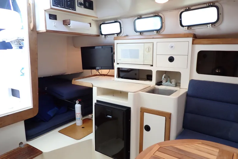 Slide: The Image of Interior of 2000 Albin 28 Tournament Express with kitchenette and seating area. - 12