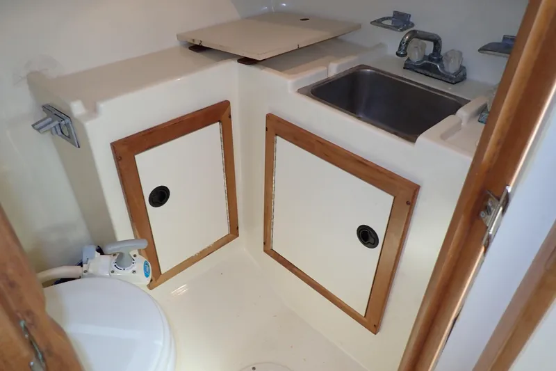 Slide: The Image of 2000 Albin 28 Tournament Express boat bathroom with sink and storage cabinets. - 15