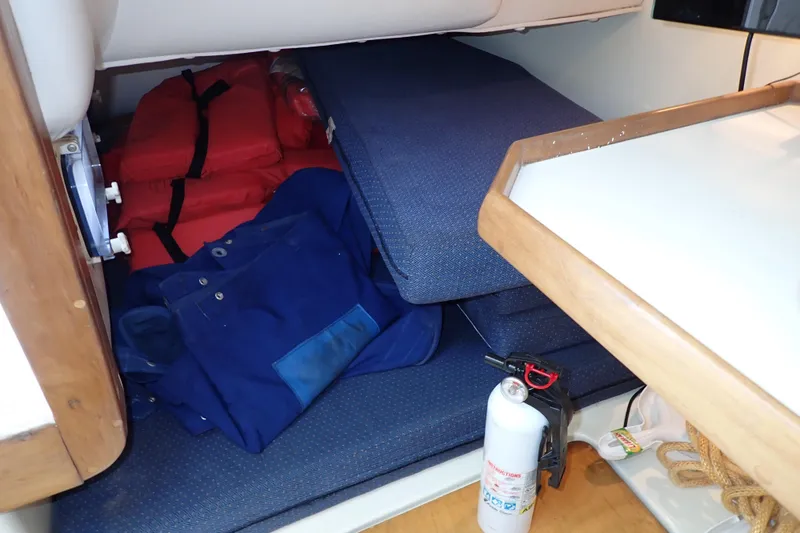 Slide: The Image of Storage area in a 2000 Albin 28 Tournament Express with life jackets and fire extinguisher. - 16
