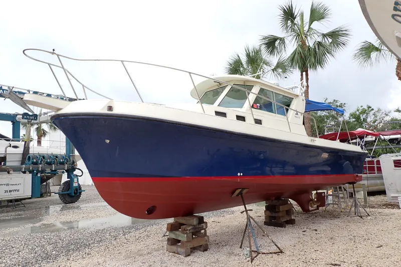 Slide: The Image of 2000 Albin 28 Tournament Express boat on dry dock with palm trees in background. - 2