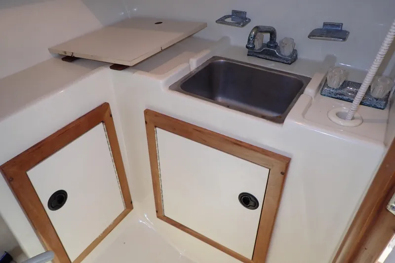 Slide: The Image of Compact galley area in 2000 Albin 28 Tournament Express with sink and storage cabinets. - 50