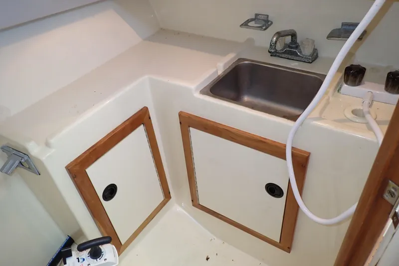 Slide: The Image of 2000 Albin 28 Tournament Express interior with sink and storage cabinets. - 52