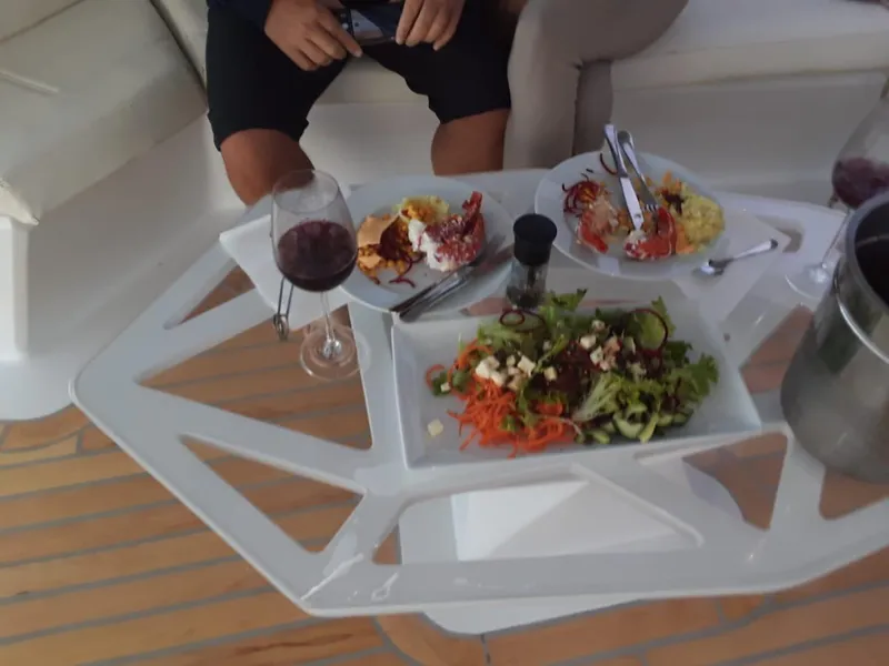 Slide: The Image of Dining setup on Leeuwin 55 yacht, featuring gourmet dishes and wine, 2024 model. - 22