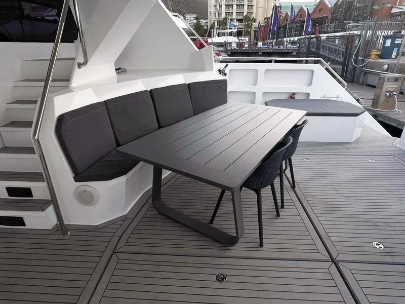 Slide: The Image of Outdoor seating area on 2024 Leeuwin 55 yacht with modern table and cushions. - 23