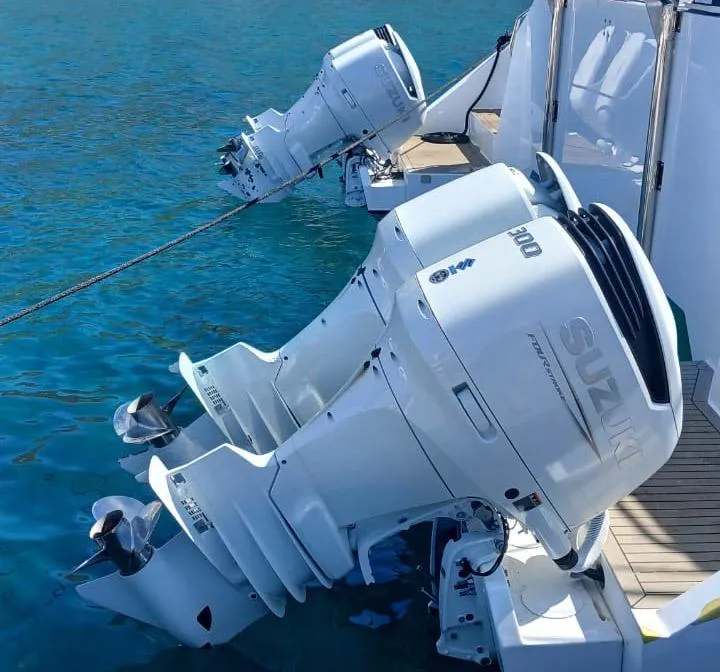 Slide: The Image of Twin Suzuki outboard motors on a 2024 Leeuwin 55 yacht, docked in clear blue water. - 24