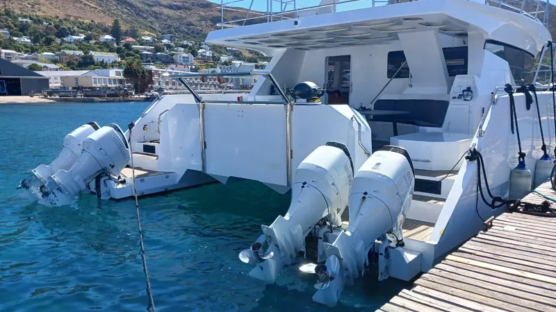 Slide: The Image of 2024 Leeuwin 55 boat docked with dual outboard motors, scenic coastal backdrop. - 25