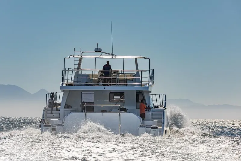 Slide: The Image of 2024 Leeuwin 55 yacht cruising on open water with mountains in the background. - 3