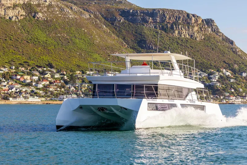 Slide: The Image of 2024 Leeuwin 55 yacht cruising near scenic coastal cliffs and residential area. - 4