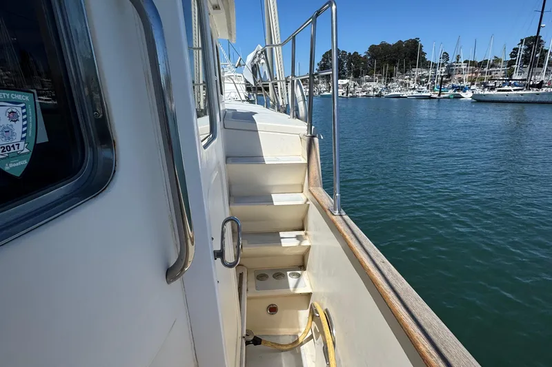 Slide: The Image of Side view of 1995 Nordhavn 46 yacht with marina background. - 10