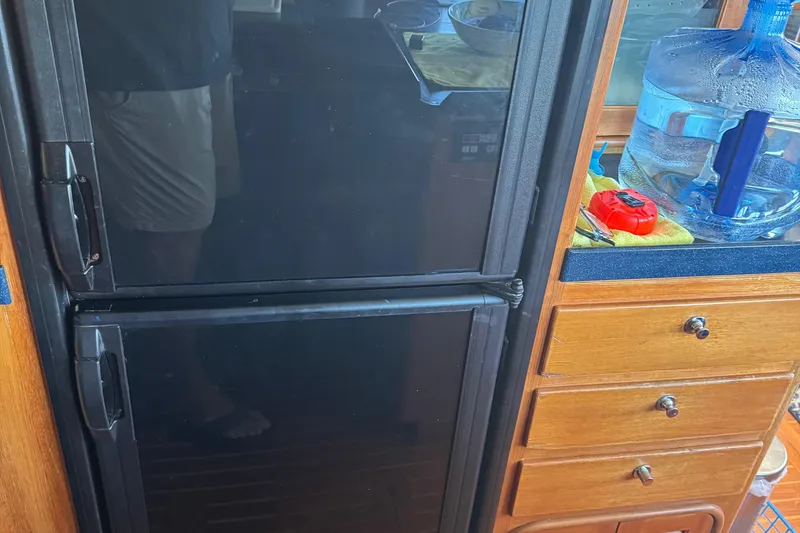 Slide: The Image of Refrigerator and wooden drawers inside a 1995 Nordhavn 46 boat kitchen. - 11