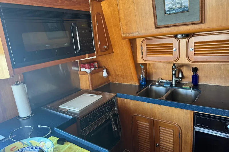 Slide: The Image of 1995 Nordhavn 46 yacht kitchen with microwave, stove, and double sink. - 13