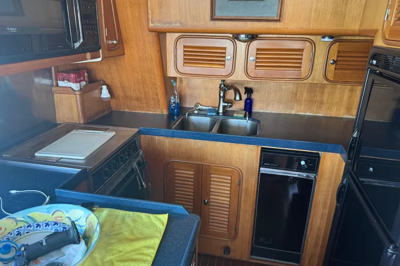 Slide: The Image of 1995 Nordhavn 46 yacht kitchen with wooden cabinets, double sink, and modern appliances. - 15