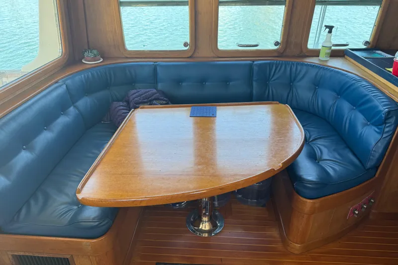 Slide: The Image of Cozy dining area on a 1995 Nordhavn 46 yacht with blue leather seating. - 16