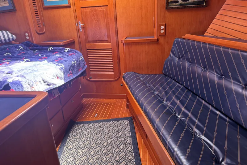 Slide: The Image of Cozy cabin interior of 1995 Nordhavn 46 yacht with wooden finish and blue seating. - 21