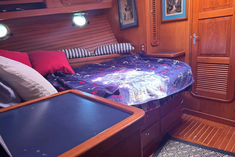 Slide: The Image of Cozy cabin interior of a 1995 Nordhavn 46 yacht with nautical-themed bedding. - 23