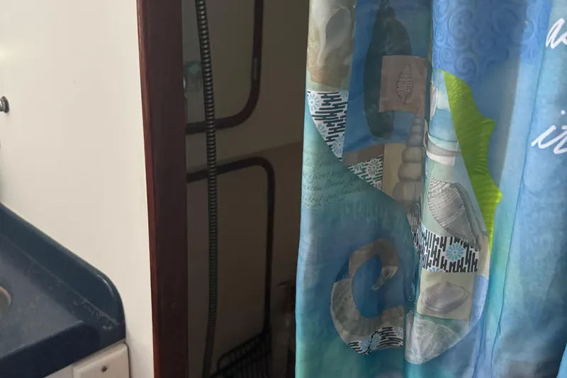 Slide: The Image of Shower area in a 1995 Nordhavn 46 boat with a colorful curtain. - 24
