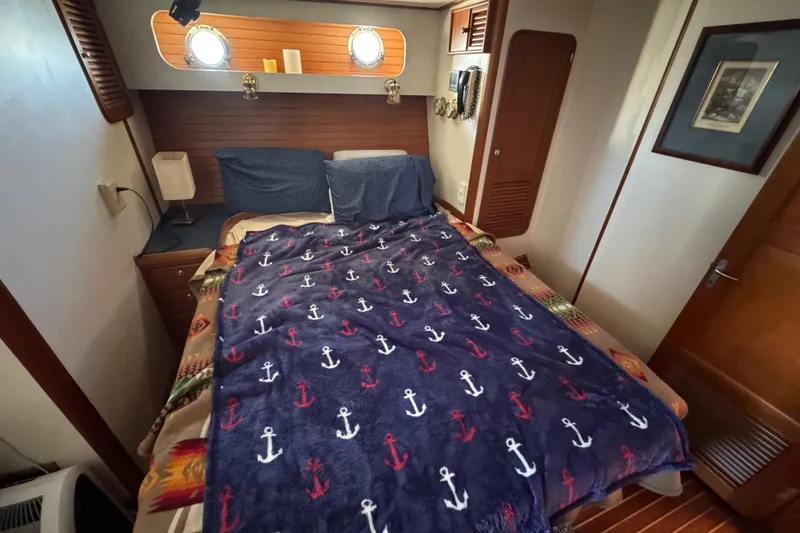 Slide: The Image of Cozy cabin interior of 1995 Nordhavn 46 with nautical-themed bedding and wooden accents. - 38