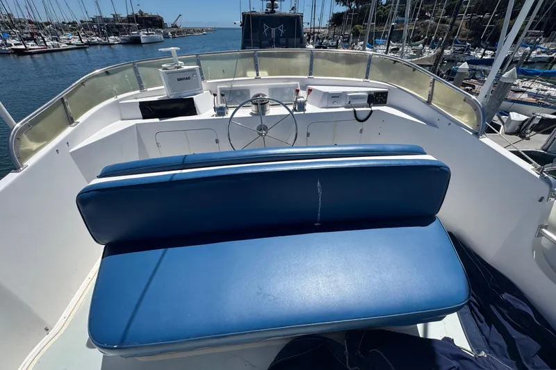 Slide: The Image of 1995 Nordhavn 46 yacht helm with blue seating, docked in a marina. - 5