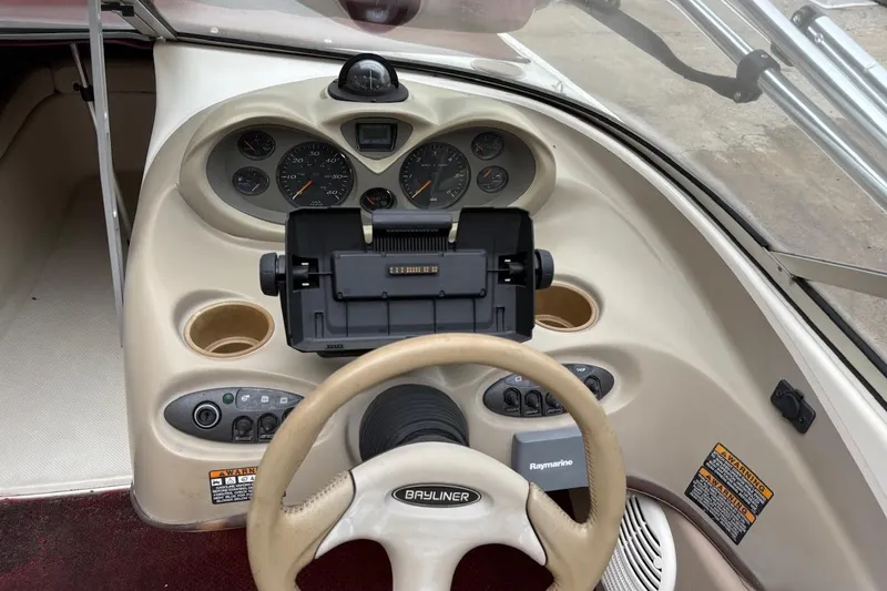 Slide: The Image of 2001 Bayliner 210 Classic boat dashboard with steering wheel and instrument panel. - 7