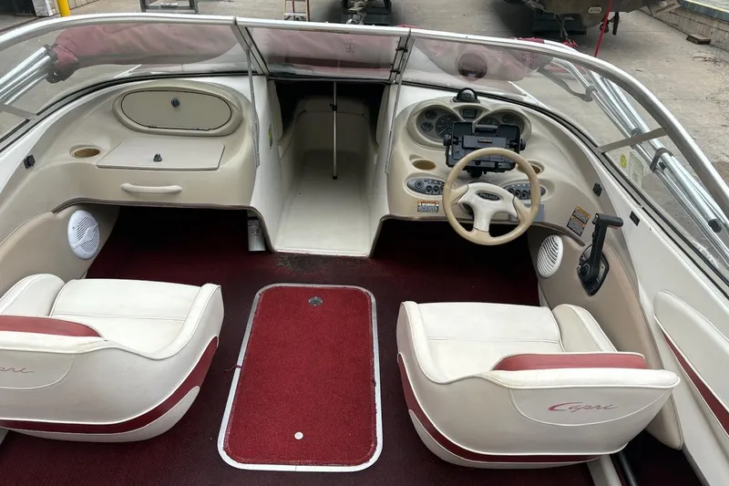 Slide: The Image of Interior of a 2001 Bayliner 210 Classic boat with red carpet and white seating. - 8