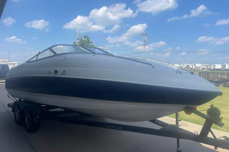 Slide: The Image of 1999 Bryant 214 Cuddy boat on trailer under a clear blue sky. - 2