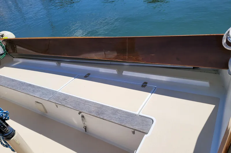 Slide: The Image of 2004 Alerion Express 28 sailboat cockpit with wooden trim and storage compartments. - 13