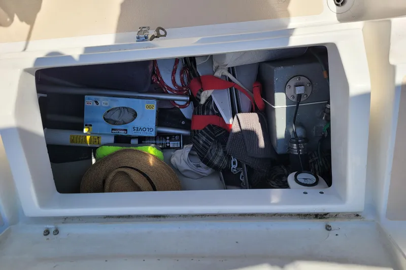 Slide: The Image of Storage compartment of a 2004 Alerion Express 28 sailboat with various items. - 18