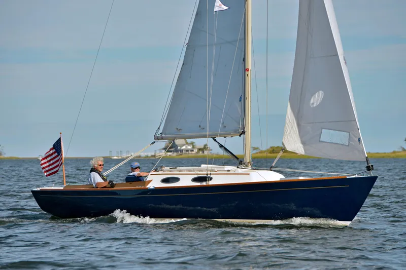 Slide: The Image of 2004 Alerion Express 28 sailboat with two people sailing on a sunny day. - 2