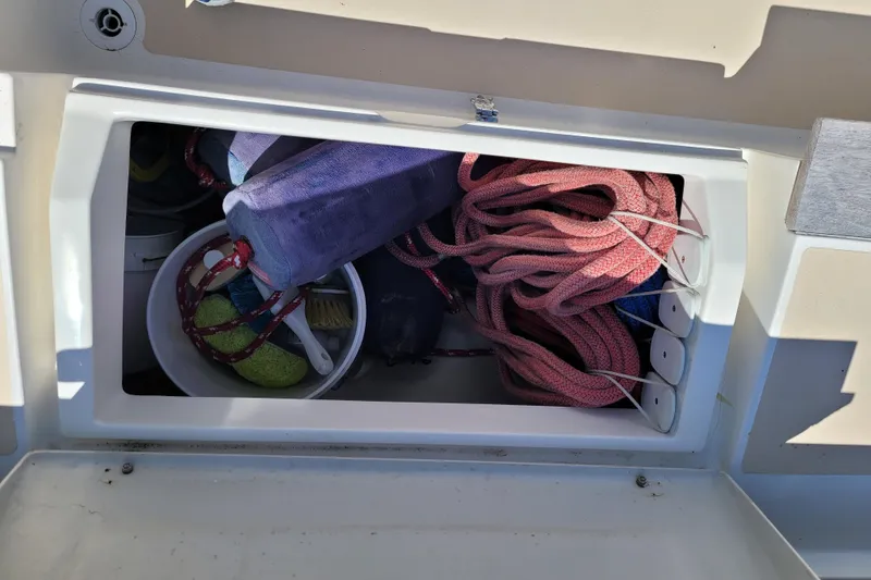 Slide: The Image of Storage compartment on a 2004 Alerion Express 28 sailboat with ropes and cleaning supplies. - 22