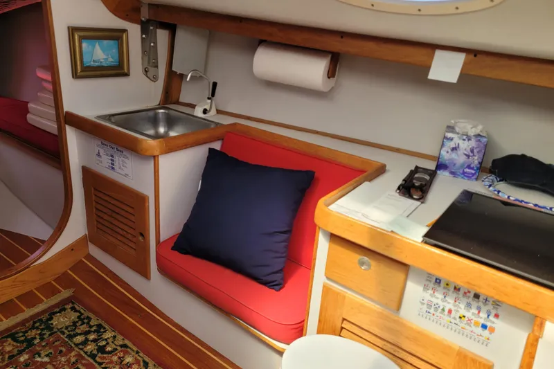 Slide: The Image of Interior of a 2004 Alerion Express 28 sailboat with sink, seating, and nautical decor. - 26