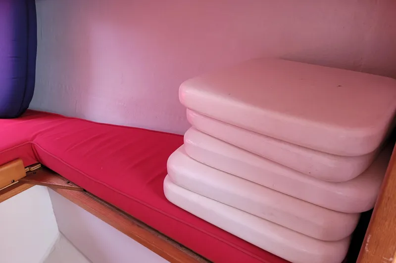 Slide: The Image of Red and pink cushions inside a 2004 Alerion Express 28 sailboat cabin. - 29