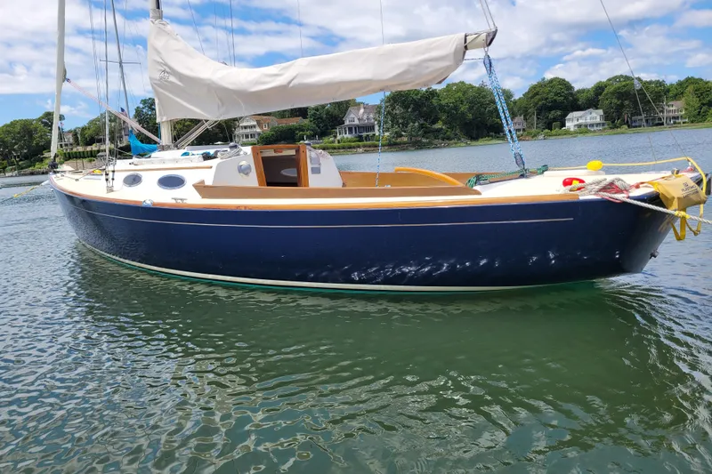 Slide: The Image of 2004 Alerion Express 28 sailboat on calm water, with scenic shoreline background. - 4