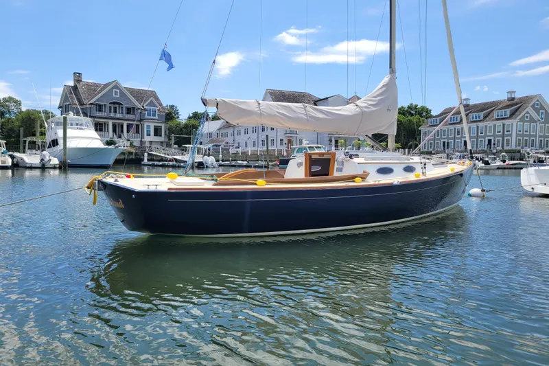 Slide: The Image of 2004 Alerion Express 28 sailboat docked in a scenic marina setting. - 5